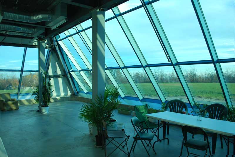 A shot from within the first floor of our glass-fronted pyramid.
Though there are only a few plants right now, our greenhouse space will soon be filled to the brim with a wide variety of plants and flowers.